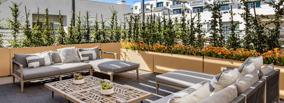 A patio with a table and chairs under a striped awning.