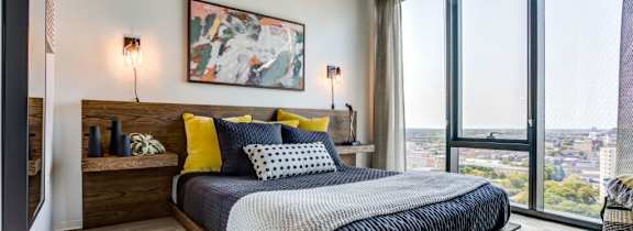 A bedroom with a large bed and a view of the city.