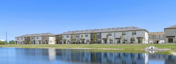 a lake sits in front of a row of apartment buildings  at Beacon at Arbours, Ruskin