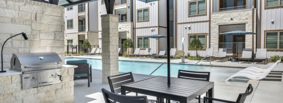 a patio with a table and chairs and a swimming pool