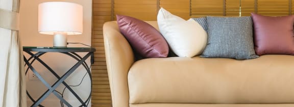 a bed with colorful pillows and a side table with a lamp