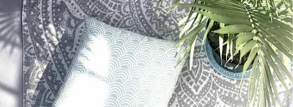 A potted plant sits on a table with a patterned cloth.