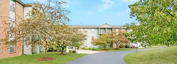 A long driveway leads to a large brick building.