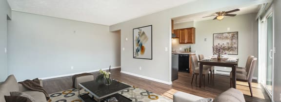 a living room with a couch and a coffee table in front of a dining room