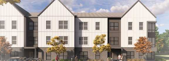A modern building with a parking lot in front.