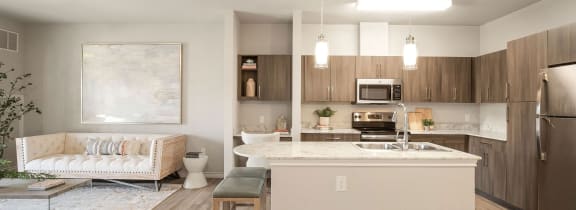 an open kitchen and living room with a marble counter top