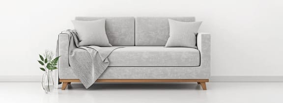 Couch and vase against a plain white wall