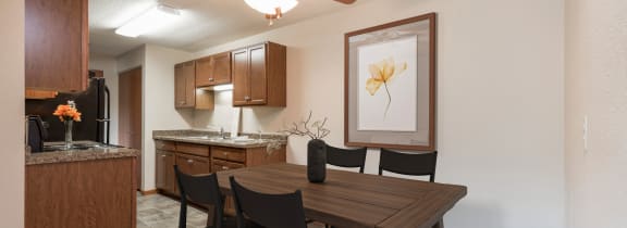 Bismarck, ND Parkview Arms |An open kitchen and dining room with a table and chairs and a ceiling fan