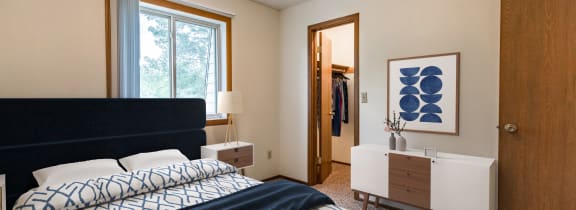Bismarck, ND Brandon |a bedroom with a large bed with a blue and white comforter