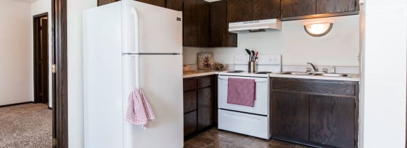 Grand Forks, ND Claremont Apartments | a kitchen with a white refrigerator and a sink