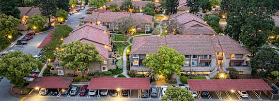 A view of a residential area with houses and parked cars.