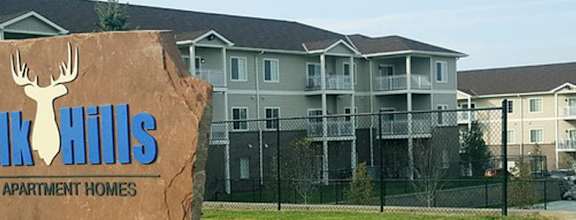 A sign for Ek Hills Apartment Homes in front of a building.