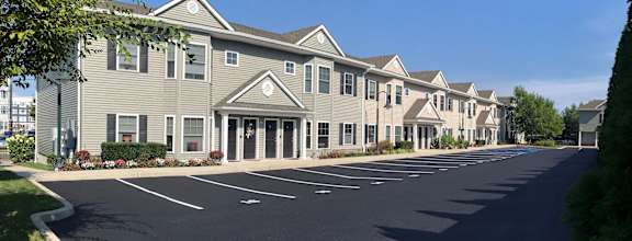 an empty parking lot in front of an apartment building