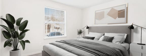 Virtually staged bedroom. Carpeted bedroom with grey and tan accent bed/artwork. Large window in background.