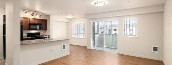 an empty living room and kitchen with wood flooring and a window  at COPPER MESA, Reno, 89508