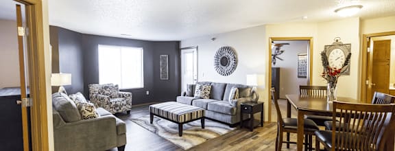 A living room with a grey couch and a wooden floor.