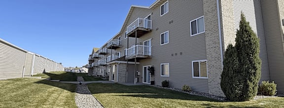 Apartment building with a grassy area in front.