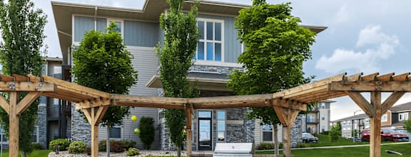 A large house with a wooden pergola in front.