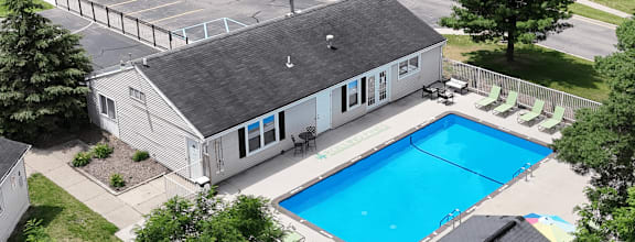 A small house with a pool in the backyard.