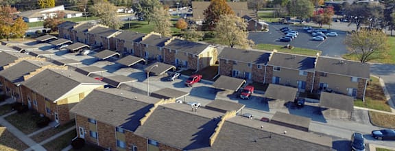 Apartment complex with a parking lot in front.
