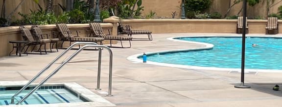 a pool with chairs around it and a jacuzzi