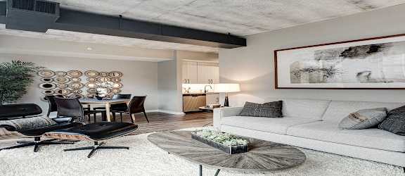 A living room with a white couch and a black chair.