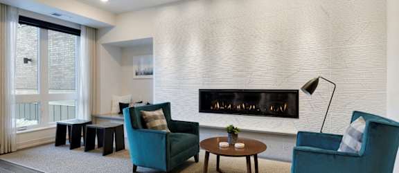 A living room with a fireplace and two chairs.