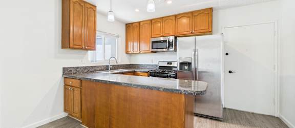 A kitchen with wooden cabinets and a granite countertop.