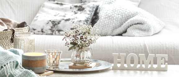 a living room with a white couch and a coffee table with a tray with a vase