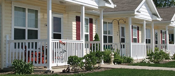 a row of houses with red doors and white columns