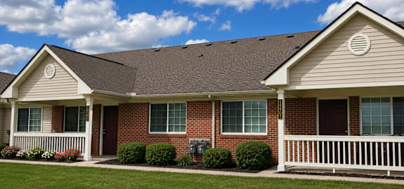 A house with a brown roof and a white fence.