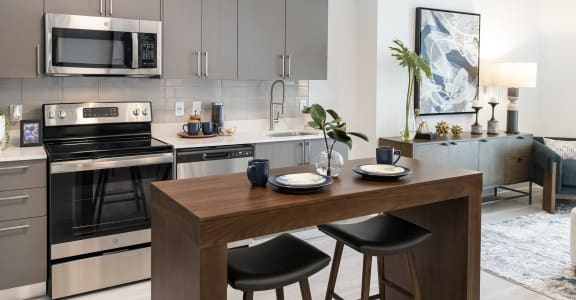 a kitchen with stainless steel appliances and a wooden table