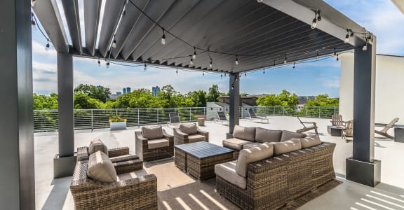 a patio with couches and chairs on a roof