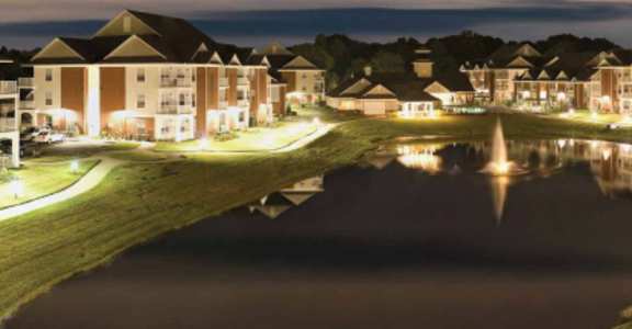 a row of houses reflected in a pond at night