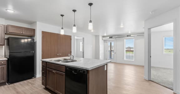 a kitchen with a large island and a black refrigerator