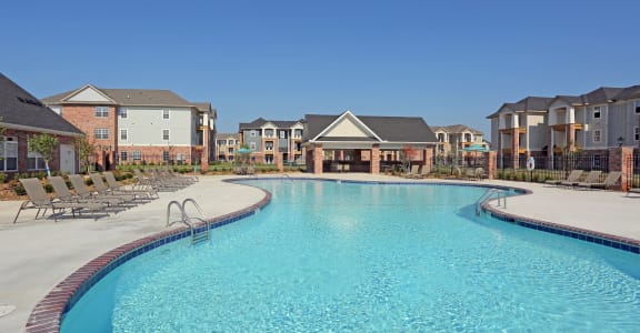 a large swimming pool with apartments in the background