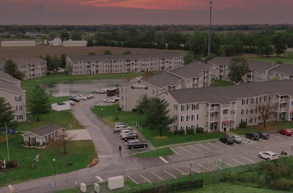 A large building complex with a parking lot in front.