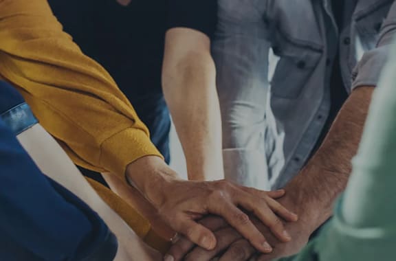 A group of people holding hands together.