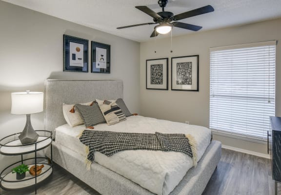 a bedroom with a large bed and a ceiling fan