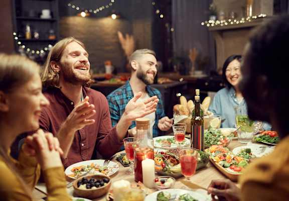A group of people are gathered around a table enjoying a meal together.