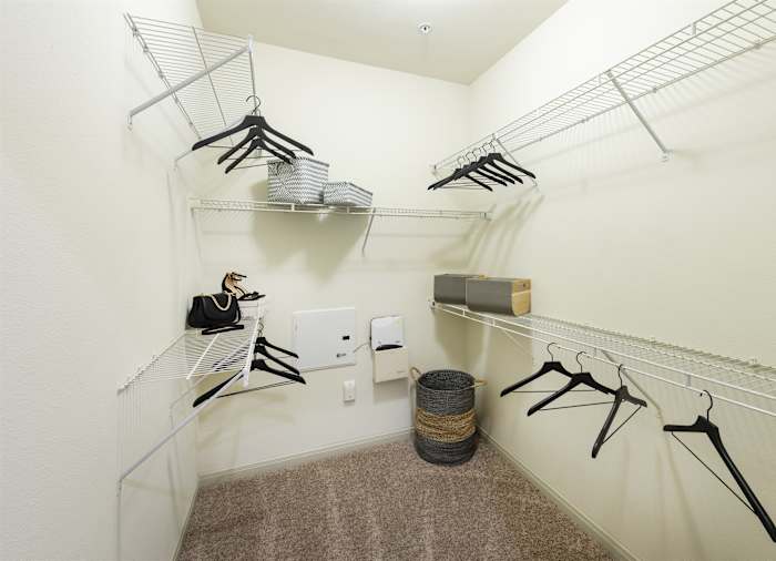 A walk-in closet with hanging rails on both sides