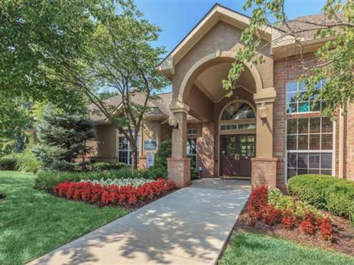 Brick clubhouse entrance with an arched portico at Crowne Chase