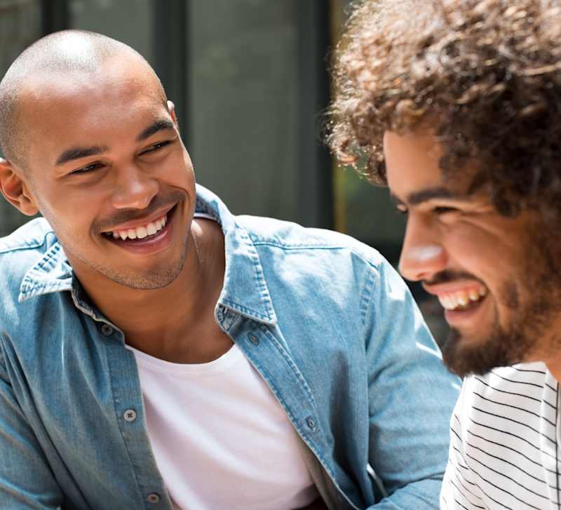 Two people laughing together over a laptop