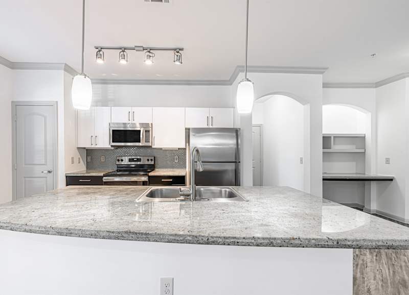 A kitchen with granite countertops and modern appliances
