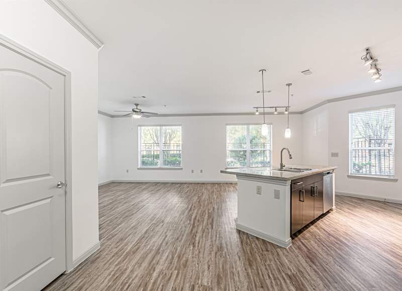 A kitchen with white cabinets and an undermount sink