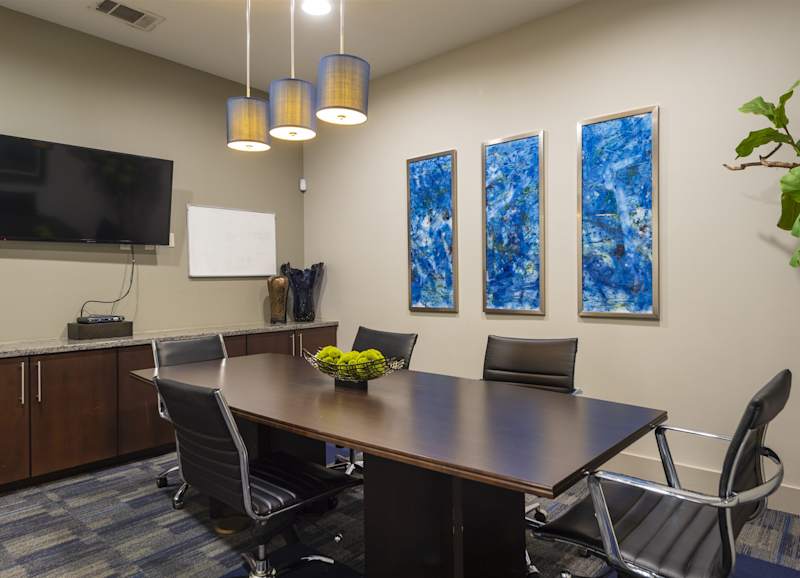 The conference room with a long table and a wall-mounted television