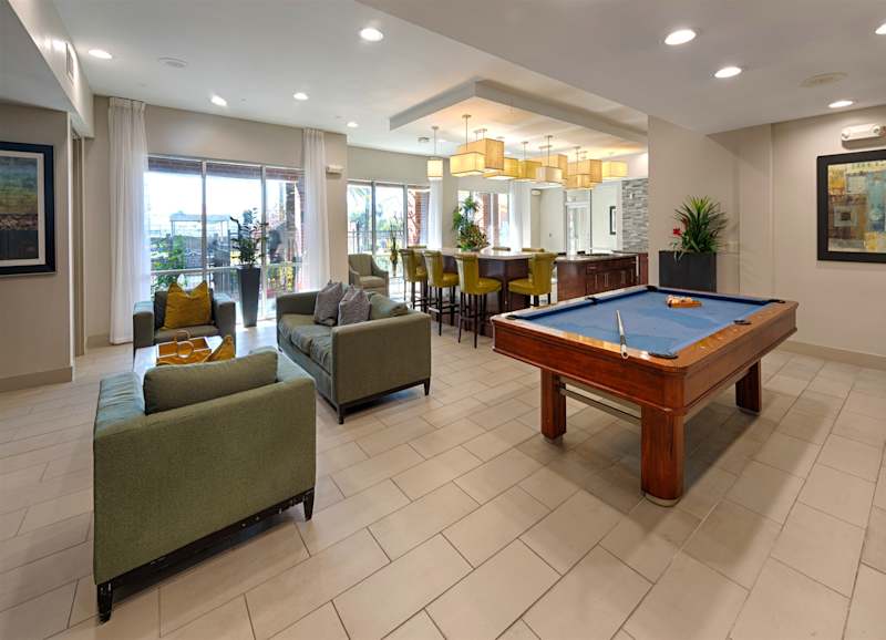 The game room with a pool table and lounge seating