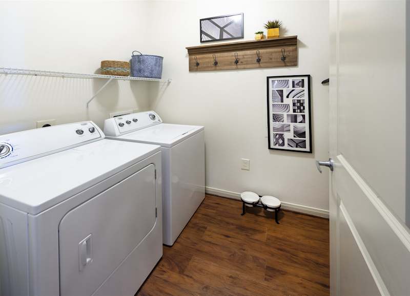 A laundry closet inside the apartment with a full-size washer and dryer