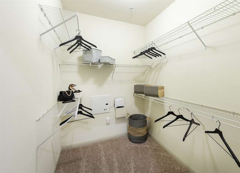 A walk-in closet with hanging rails on both sides