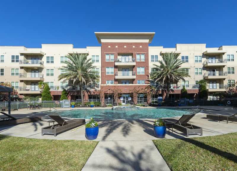 The swimming pool seen across the deck, with the apartment buildings behind